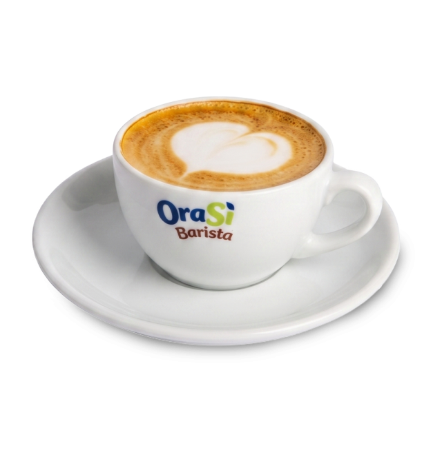 Λευκή κούπα καπουτσίνο με latte art σε σχήμα καρδιάς, ετικέτα "OraSì Barista", σε πιατάκι, λευκό φόντο