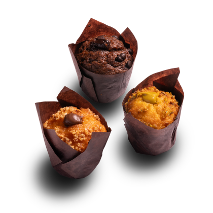 Τρία muffins σε καφέ χάρτινες θήκες: σοκολάτας, καραμέλας με κομμάτι σοκολάτας και φιστικιού, σε λευκό φόντο