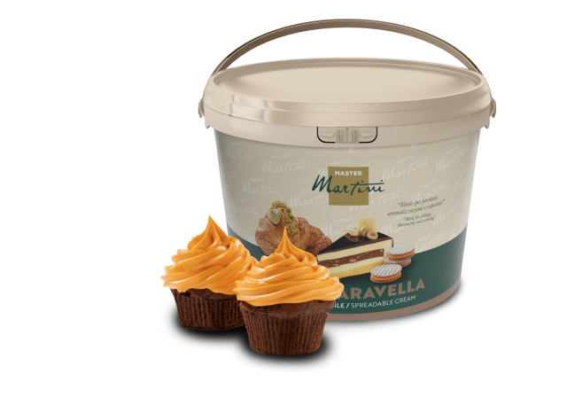 Μπεζ κουβάς κρέμας επάλειψης Master Martini με δύο cupcakes σοκολάτας με πορτοκαλί γλάσο μπροστά.